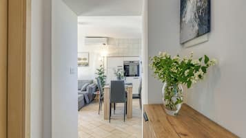 Una cucina moderna con zona pranzo, un tavolo di legno e un vaso con fiori.