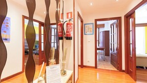 A hotel hallway with wooden floors, a fire extinguisher, and a sign for 'basilikey rentals'.