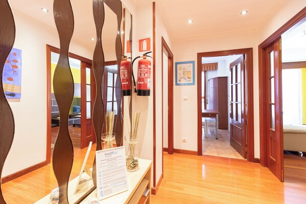 A hotel hallway with wooden floors, a fire extinguisher, and a sign for 'basilikey rentals'. - Larraigana - baskeyrentals (Gizaburuaga)