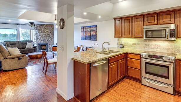 A modern kitchen with granite countertops, stainless steel appliances, and wooden cabinets. - Golf Views & Pool Access: Central Scottsdale Condo (Scottsdale)