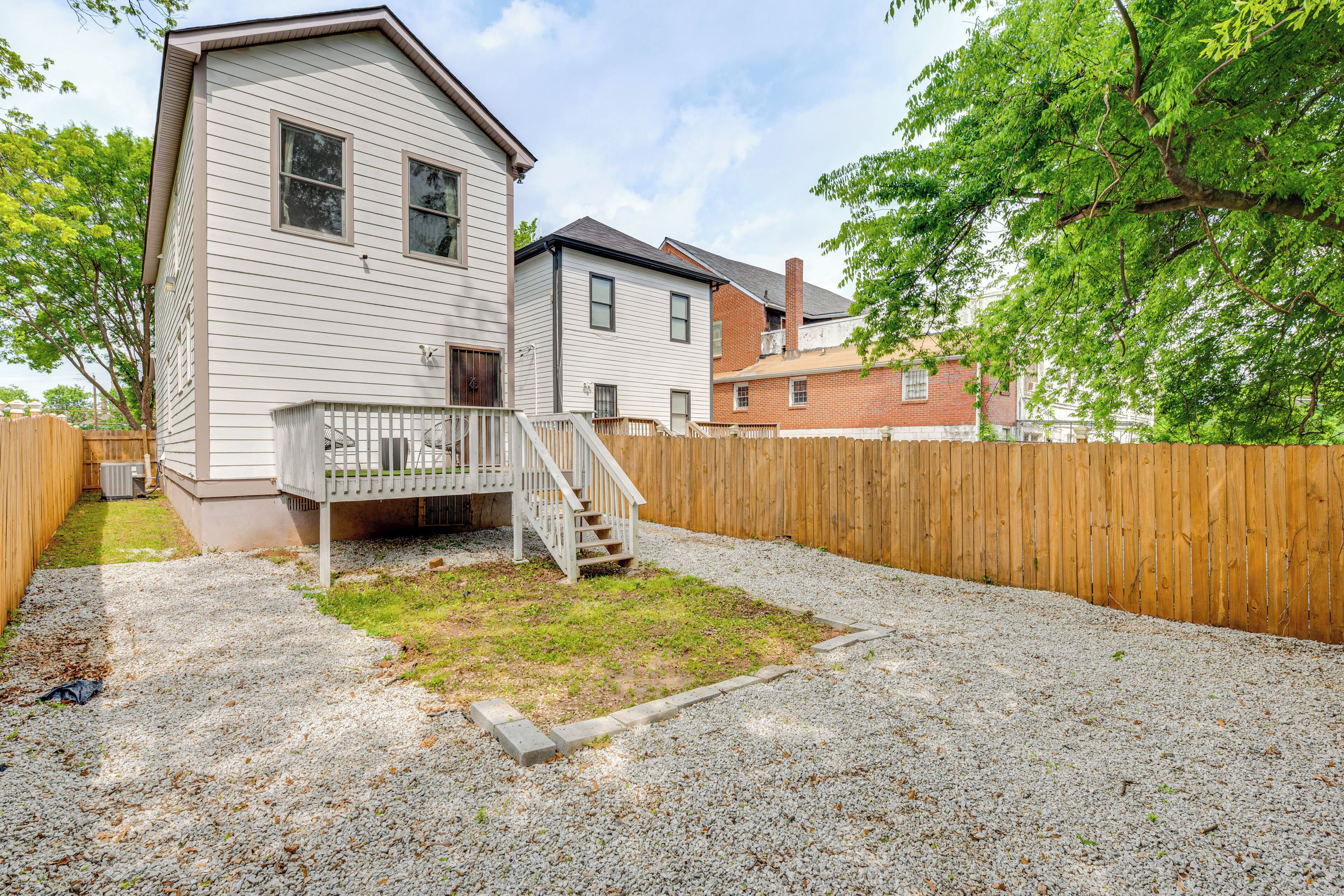A two-story house with a front porch and a wooden fence.
