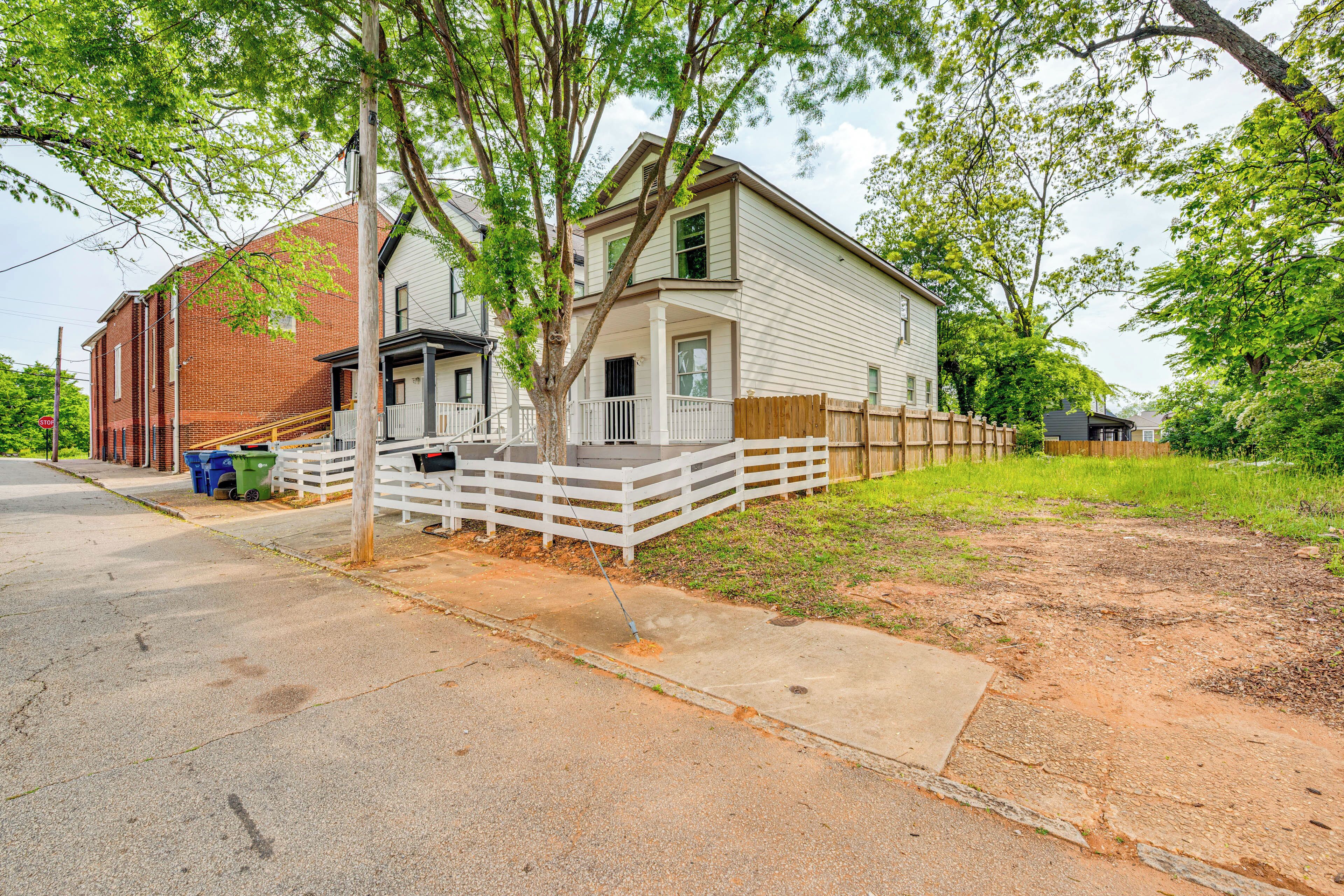 A two-story house with a porch and a fenced yard.