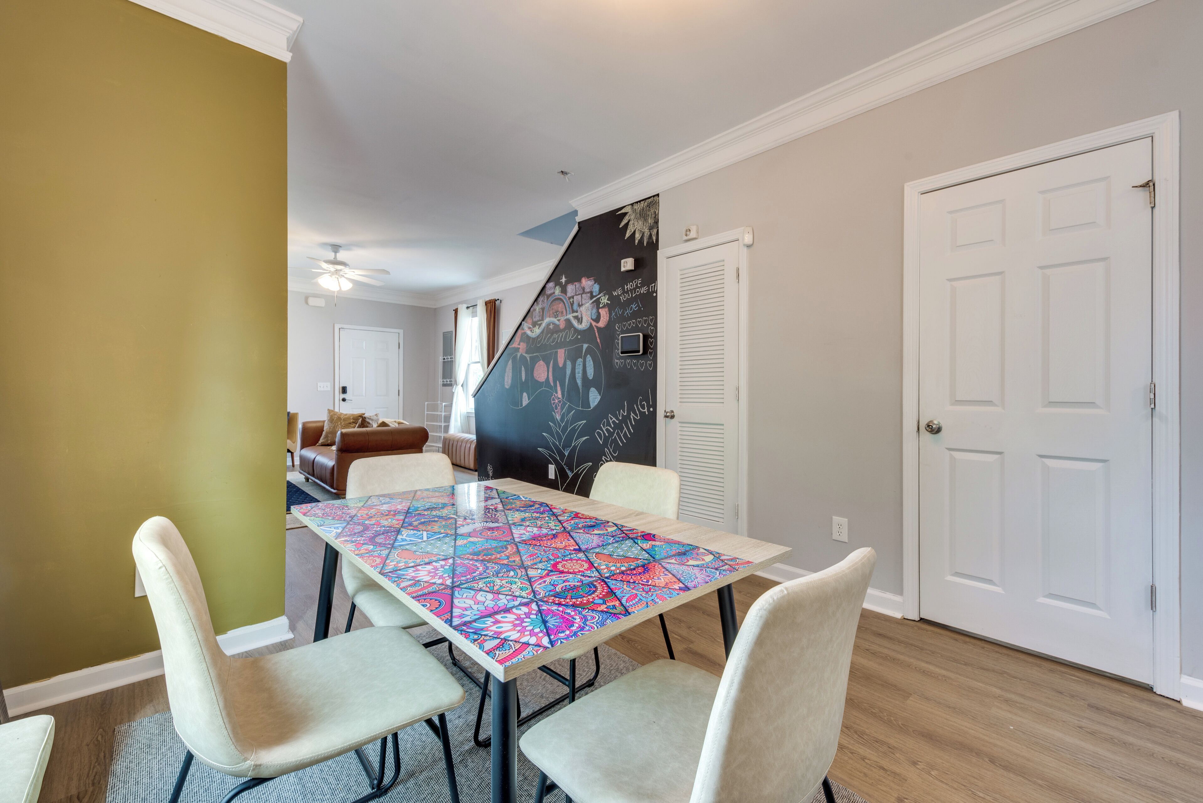 Un coin repas avec une table recouverte d’une nappe colorée, entourée de quatre chaises.