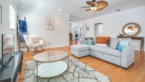A living room with a sectional sofa, a glass coffee table, a ceiling fan, and a television. - 4 Mi to Beaches: Tranquil Fort Lauderdale Escape (Fort Lauderdale)