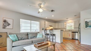 A modern living room with a grey sofa, a wooden coffee table, and a ceiling fan.