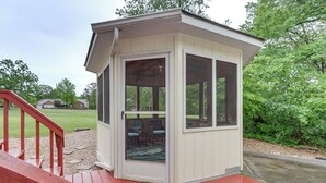 A small, enclosed outdoor structure with a door and windows, likely a covered seating area or a small room. - Holiday Island Family Home on 13th Green! (Eureka Springs)