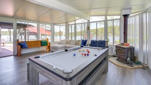 A pool table in a room with a sofa and a fireplace.