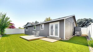 A modern house with a well-maintained lawn, a patio with outdoor furniture, and a large garage. - Updated Family Home w/ Fenced Yard in Yakima! (Yakima)
