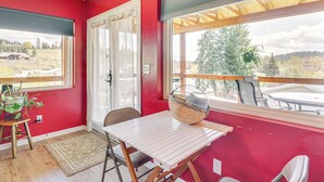 Una habitación con paredes rojas, una mesa blanca y un ventanal con vistas panorámicas.