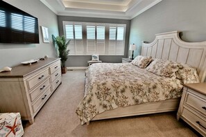 A bedroom with a bed, dresser, nightstand, TV, window with shutters, and a potted plant. - Rehoboth Beach, Dog Friendly, 5BR, 3 Full Baths, Arbor-Lyn Community, Sleeps 12 (Rehoboth Beach)
