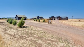 A rural road with several buildings, including a barn and a house with a metal roof. - Walk to Wineries: Elgin Wine Country Retreat! (Elgin)