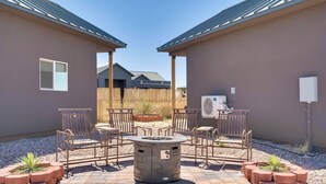 A patio area with a fire pit, seating, and a view of a house in the background. - Walk to Wineries: Elgin Wine Country Retreat! (Elgin)