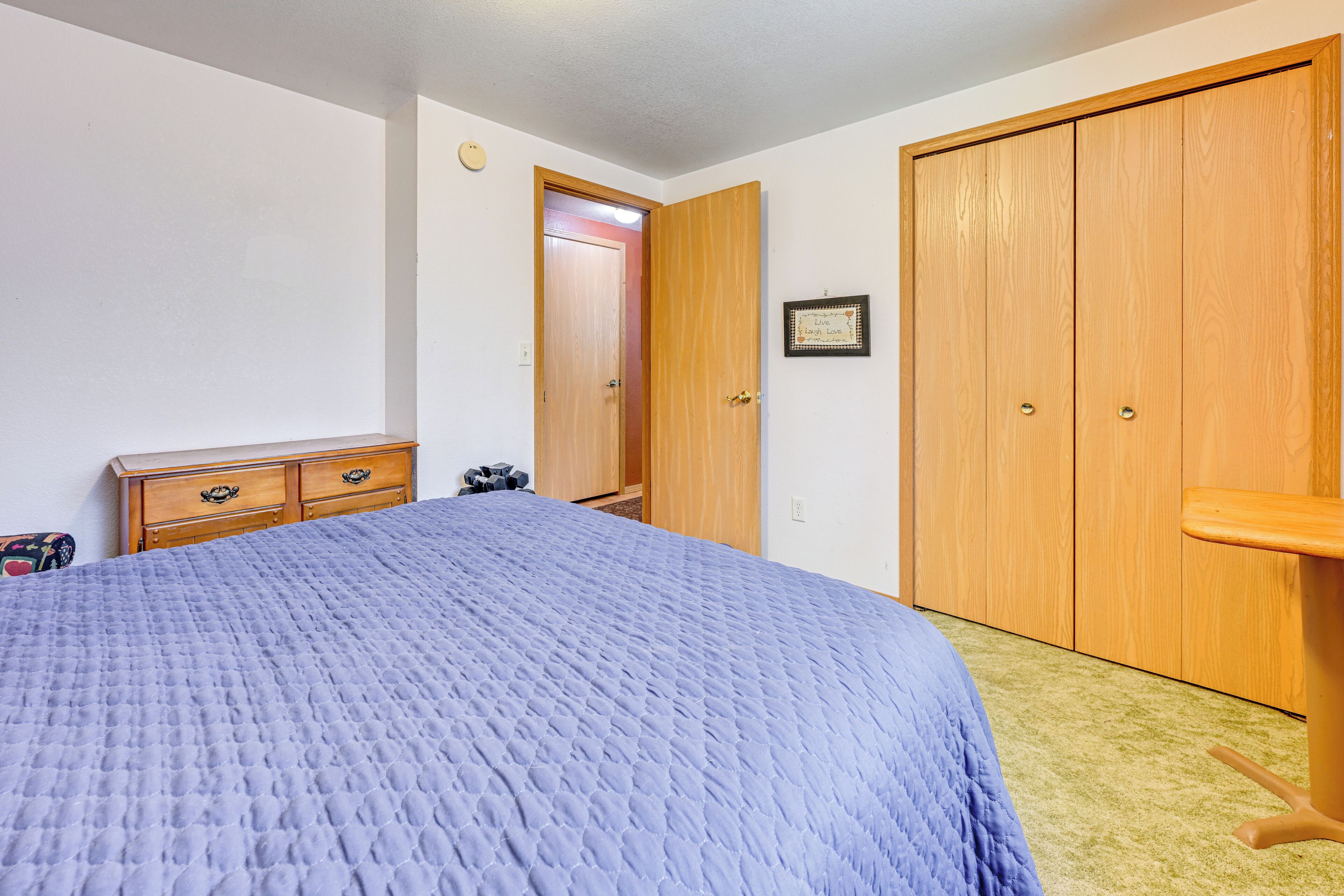 Ein Schlafzimmer mit einem Bett, einem Holzschrank und einer Kommode.