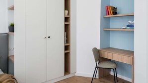 Un dormitorio con una cama, un escritorio y un armario.