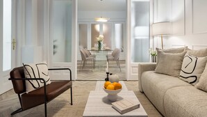 A modern living room with a brown leather sofa, a beige sofa, and a dining area with a glass table and chairs. - Elegant 3BR Retreat - Steps Away Cismigiu Gardens (Bucharest)