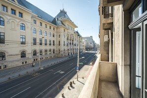 A wide street with a building featuring classical architecture, a clear sky, and a pedestrian walkway. - Elegant 3BR Retreat - Steps Away Cismigiu Gardens (Bucharest)