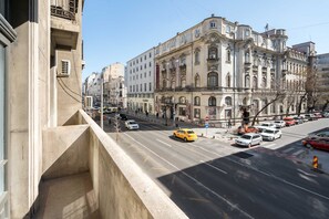A street view with a prominent historical building, a clear sky, and vehicles on the road. - Elegant 3BR Retreat - Steps Away Cismigiu Gardens (Bucharest)