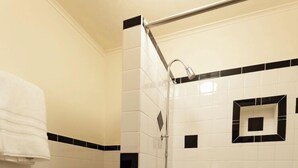 A bathroom with a white toilet, a bathtub, and a shower. - Jesse James - Historic Hotel (Cimarron)