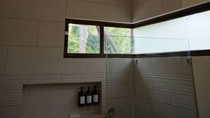 Un baño con ventilador de techo, ventana y zona de ducha.