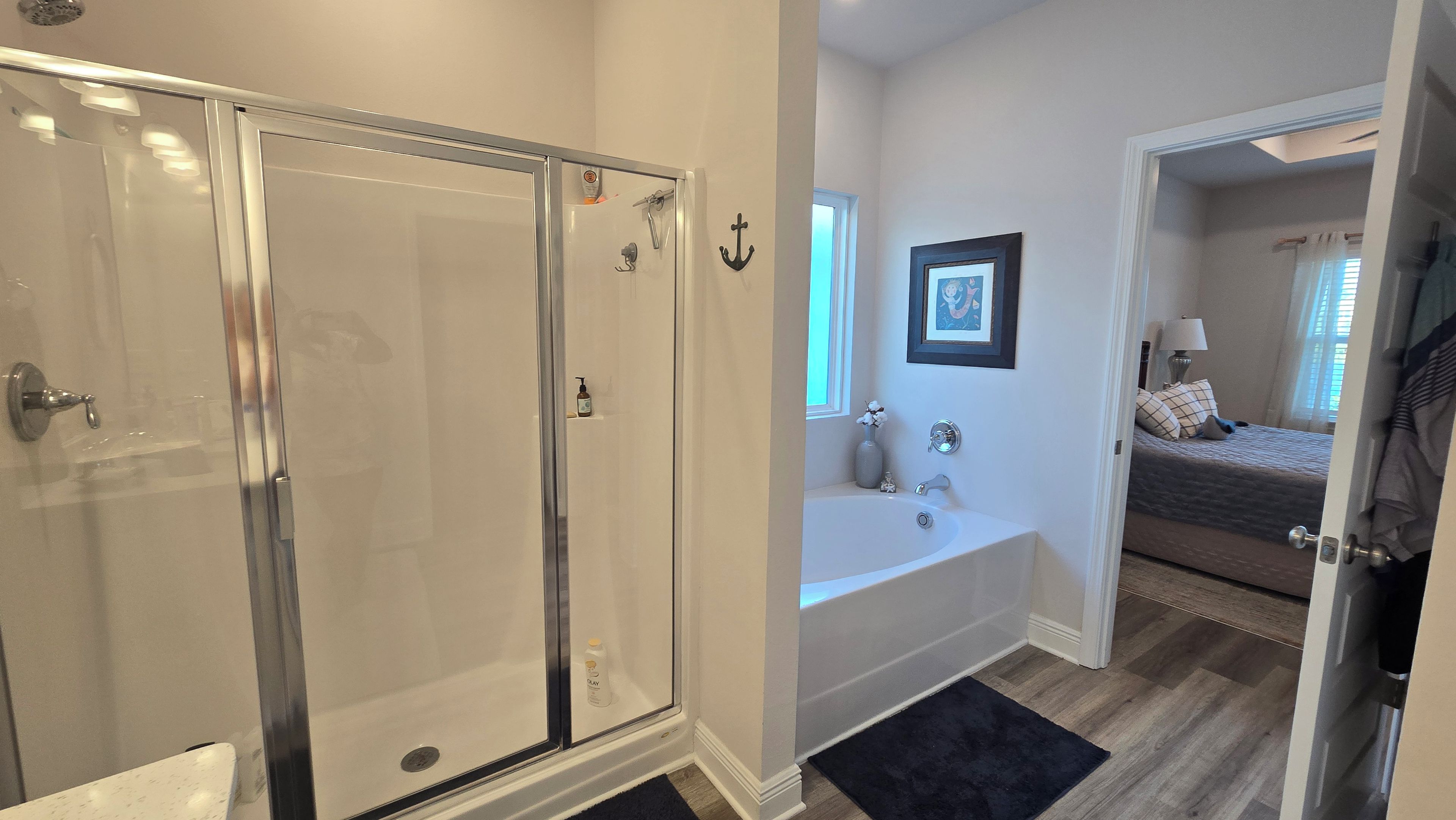 A bathroom with a glass-enclosed shower, a bathtub, and a toilet.