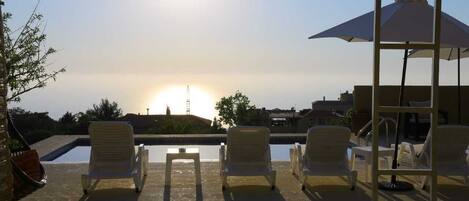 Een seizoensgebonden buitenzwembad en parasols bij het zwembad