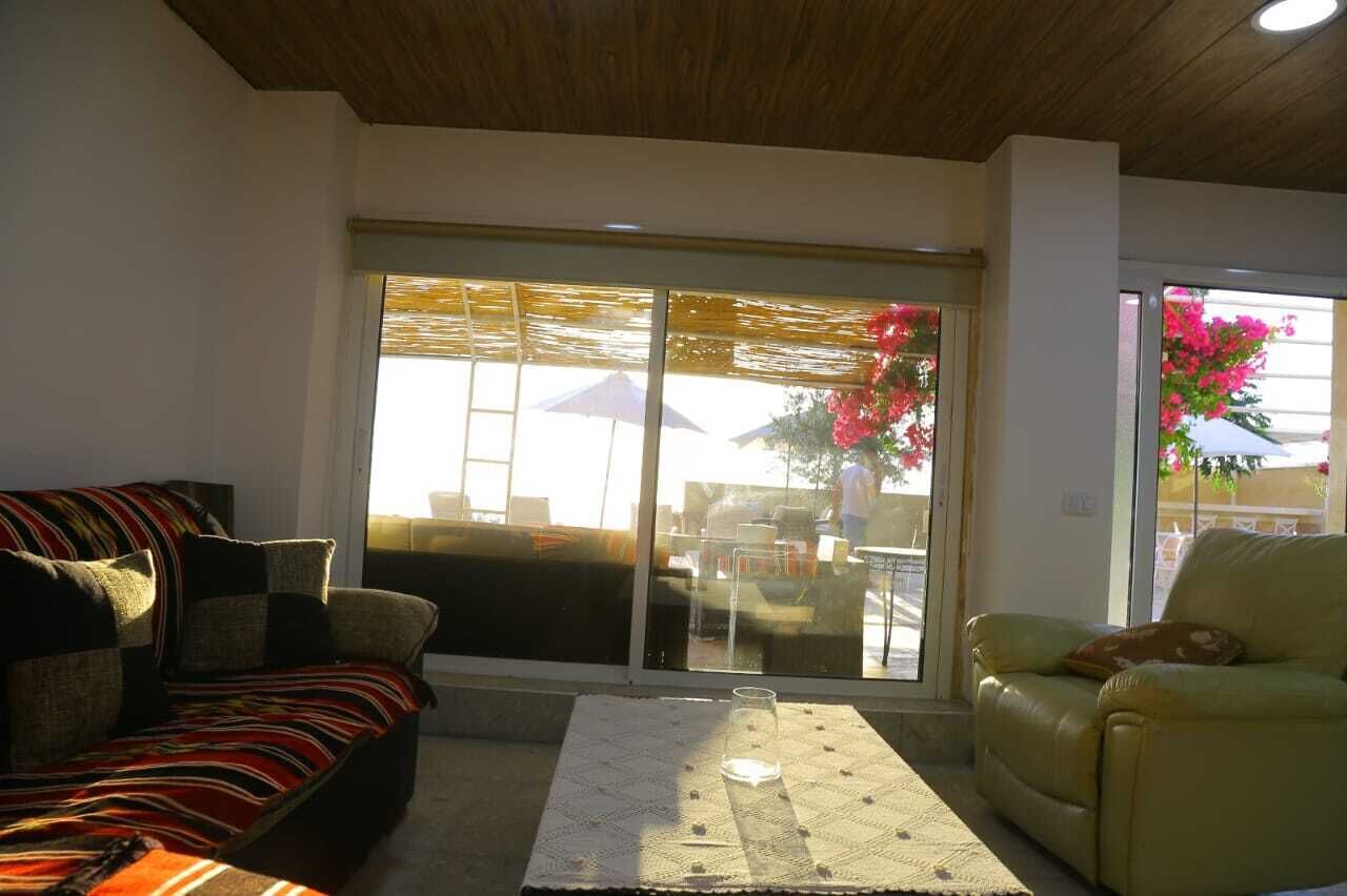 A living room with a sofa, a chair, and a glass table.