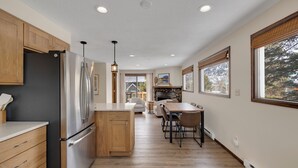 A modern kitchen with wooden cabinets, stainless steel appliances, and a central island. - Downtown Modern Frisco Getaway (Frisco)