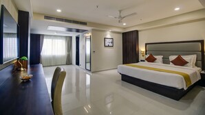 A hotel room with a large bed, a dining table, and a separate dining area. - The Bindal Hotel (Jamshedpur)