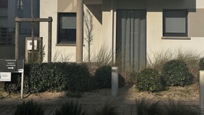 Een modern gebouw met twee verdiepingen, een balkon, een deur en een raam.