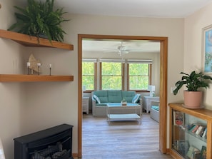 A living room with a sofa, a coffee table, a fireplace, and a bookshelf.