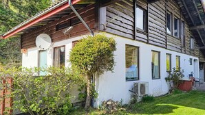 Ein rustikales Holzhaus mit Satteldach, einer Satellitenschüssel und einer Klimaanlage.