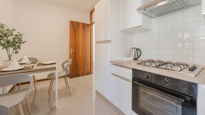 A modern kitchen with a gas stove, oven, and a coffee maker on the counter. - Unico Apt 4, Free Parking, 6 guests, for families (Mestre)