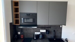 A modern kitchen with a built-in oven, microwave, and coffee maker. - Vue mer - Monaco - clim (Cap-d'Ail)