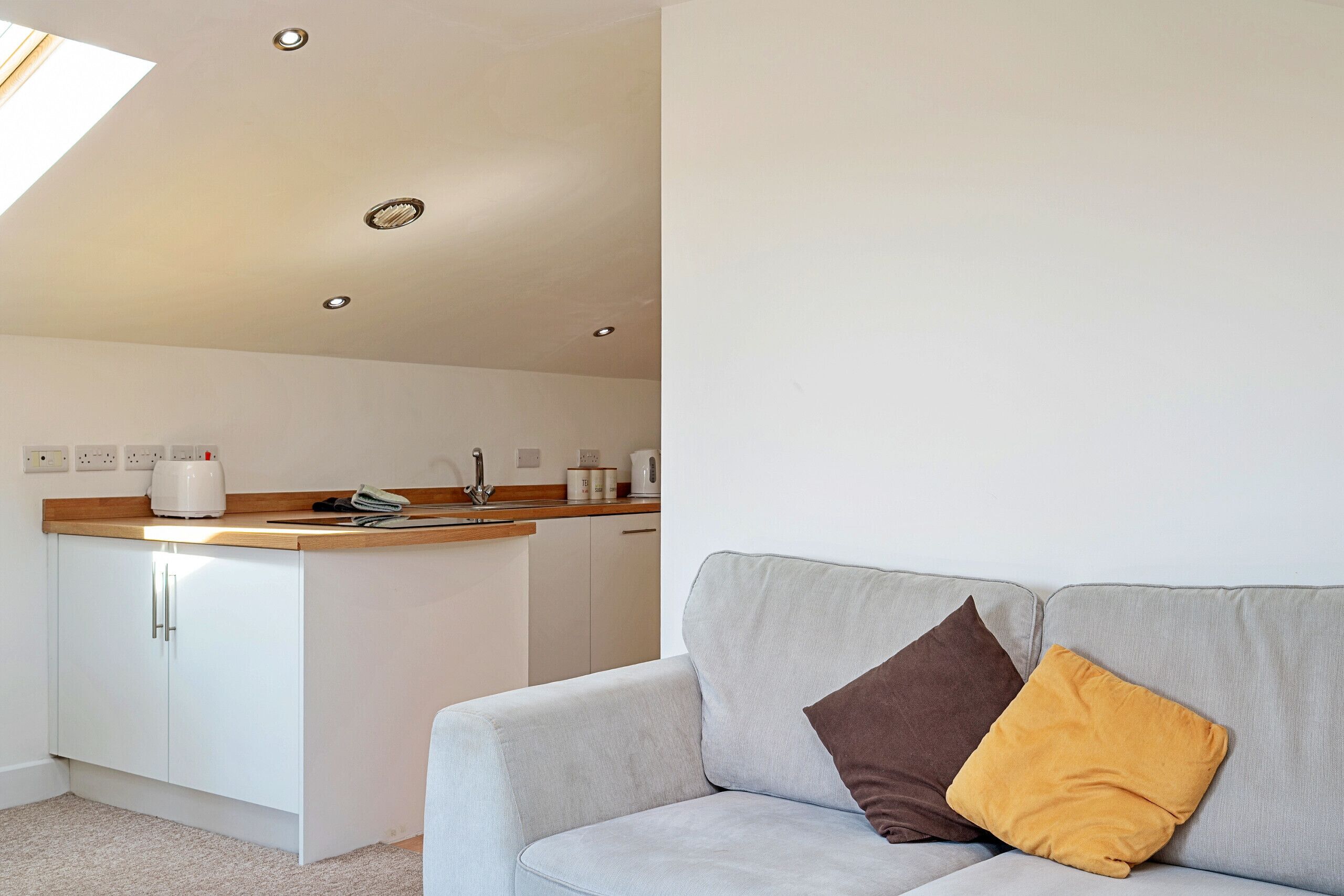 A modern kitchen with white cabinets and a wooden countertop.