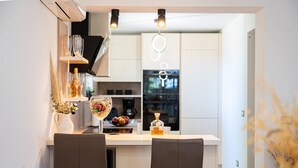 Une cuisine moderne avec un îlot central, deux chaises et une table à manger.