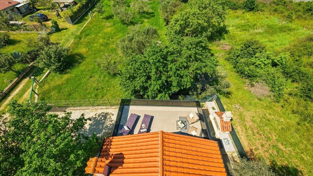 Vue aérienne d’une propriété dotée d’un patio, d’un espace salon extérieur et offrant une vue sur la mer.