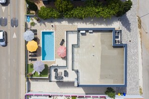An aerial view of a hotel with a swimming pool, outdoor seating, and a covered patio area. - 5-bedroom Villa Eminentia with Sea View and Private Pool (Ližnjan)