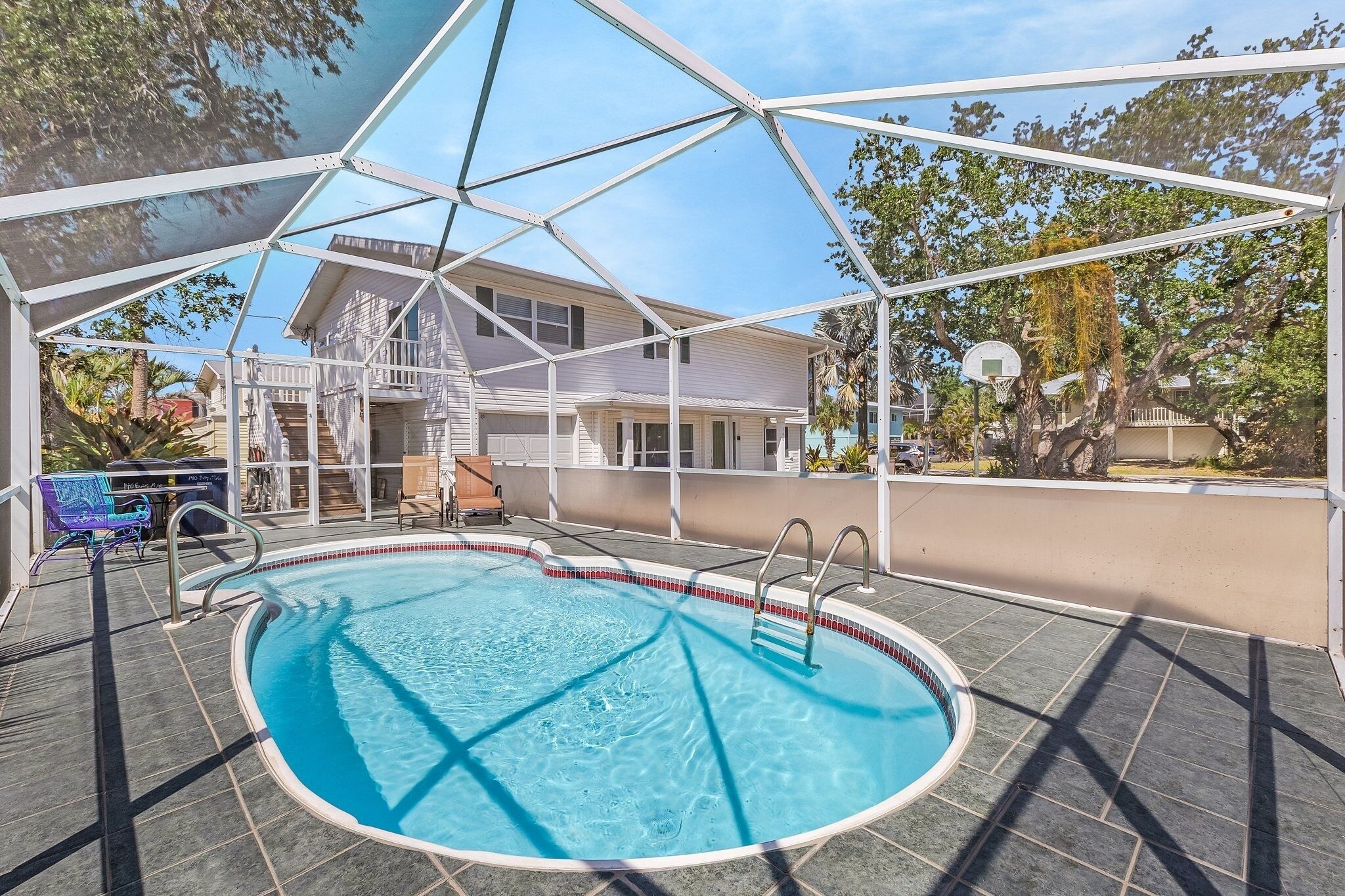A covered outdoor swimming pool with a clear view of a house in the background.