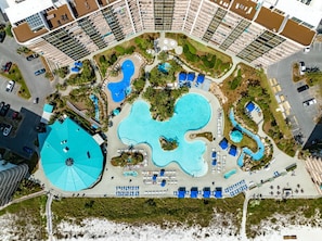 An aerial view of a resort with multiple swimming pools, a large central pool, and a variety of outdoor seating areas. - Sunrise over the Gulf - resort pools and gulf views (Panama City Beach)