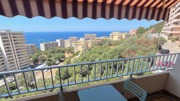 Un balcon avec vue sur la mer et les bâtiments.