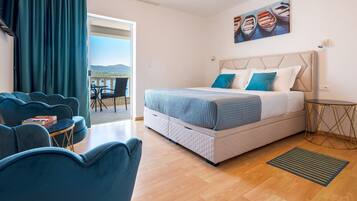 Una camera da letto moderna con un grande letto, un balcone con vista e un’area salotto con un tavolo.