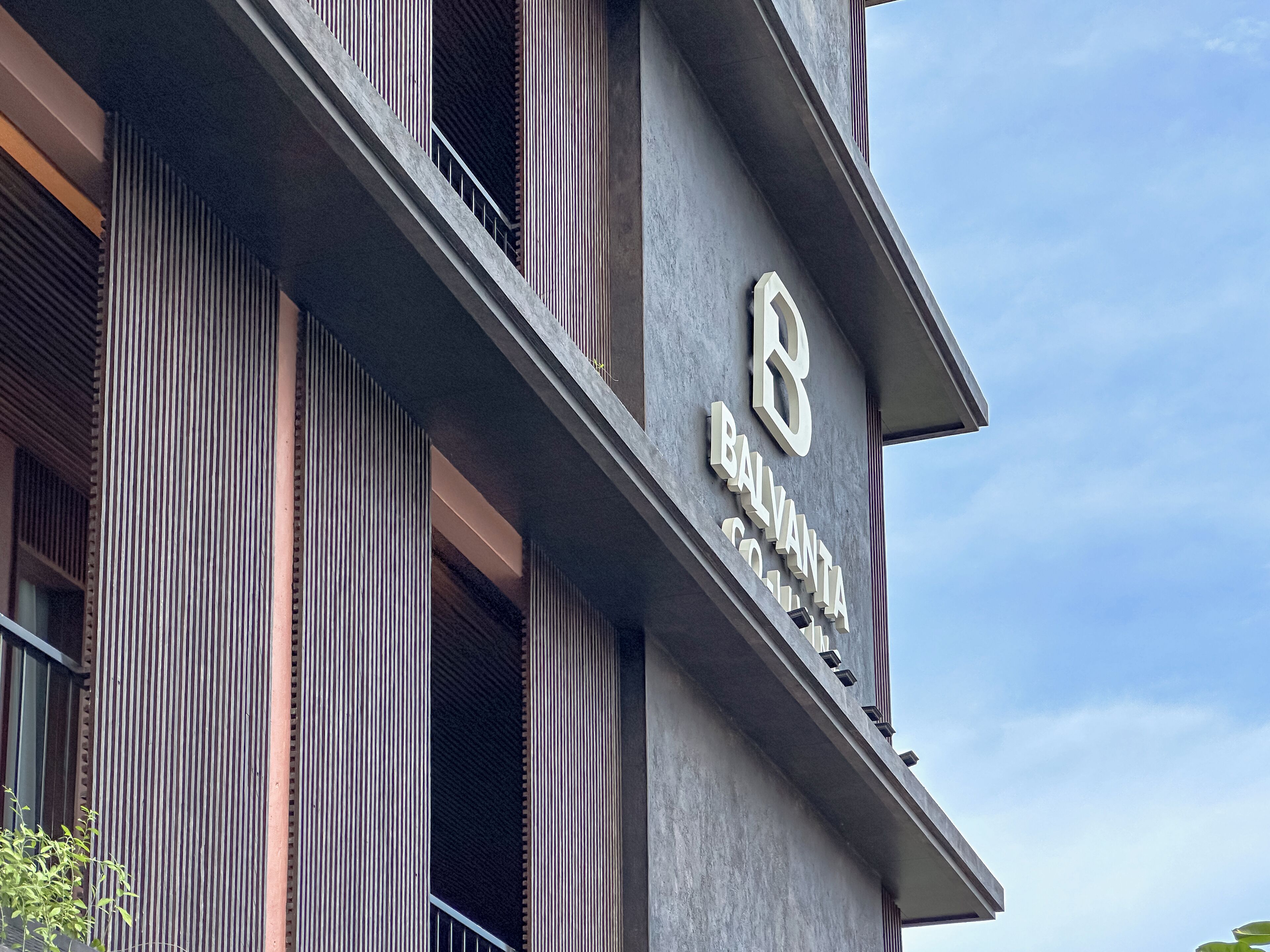 A building with a prominent '8' sign and the name 'BALVANTIA COLONY' on its facade.