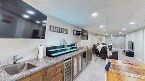 Eine moderne Küche mit Granit-Arbeitsplatten, einem eingebauten Geschirrspüler und einem an der Wand montierten Fernseher.