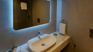 A modern bathroom with a large mirror, a sink, and a towel rack. - Center Port Hotel Karaköy (Istanbul)