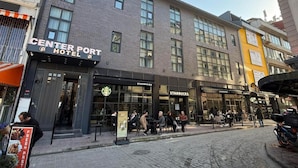 A hotel with a sign reading "Center Port Hotel" and a Starbucks across the street. - Center Port Hotel Karaköy (Istanbul)