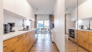 Una cucina moderna con mobili in legno, un'isola centrale e un'area pranzo con sedie.