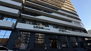 Un hotel moderno con un cartel que indica "LOJEL" y "STEPS", señalando el hotel y las suites.