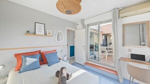 A modern hotel room with a bed, a desk with a laptop, a large window, and a balcony. - Le toit du Port : Terraces/Pool/Clim/Parking (Hyères)
