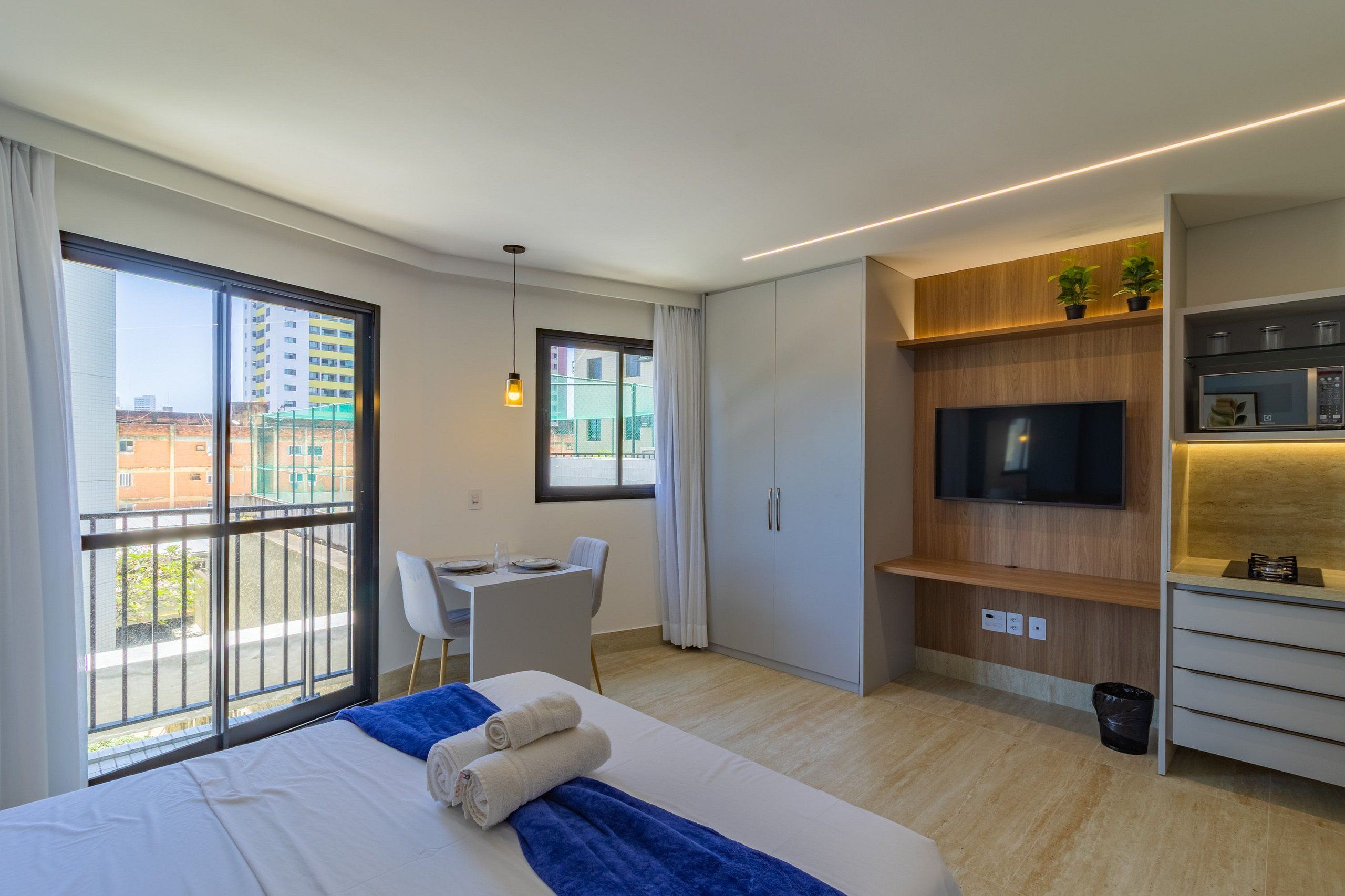 A modern hotel room with a large bed, a desk, and a TV.