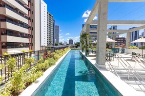 Una piscina larga con vistas a edificios altos al fondo.